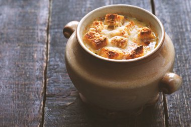 Ahşap masa yatay üzerinde seramik tencerede soğan çorbası