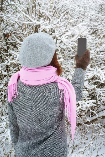 女性は、垂直冬の木の写真を撮る — ストック写真