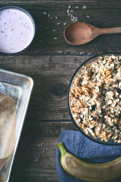 Granola en el cuenco de vidrio con diferentes accesorios en la mesa de madera vertical — Foto de Stock