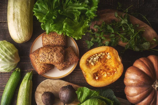 Pan de grano con diferentes verduras en la mesa de madera vista superior —  Fotos de Stock