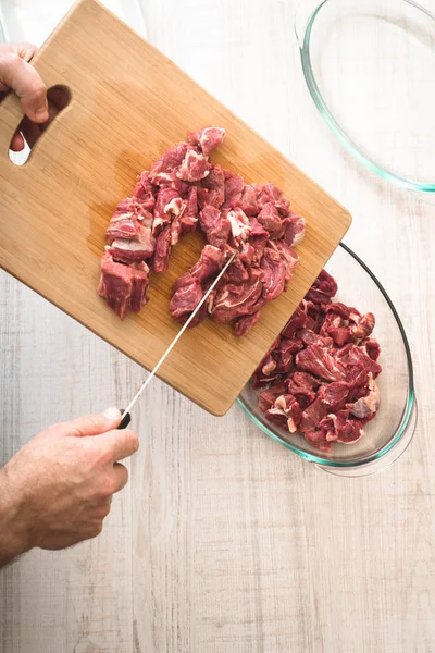 Putting raw meat in the baking dish — Stock Photo, Image