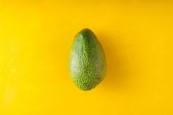 Avocado auf gelbem Tisch — Stockfoto