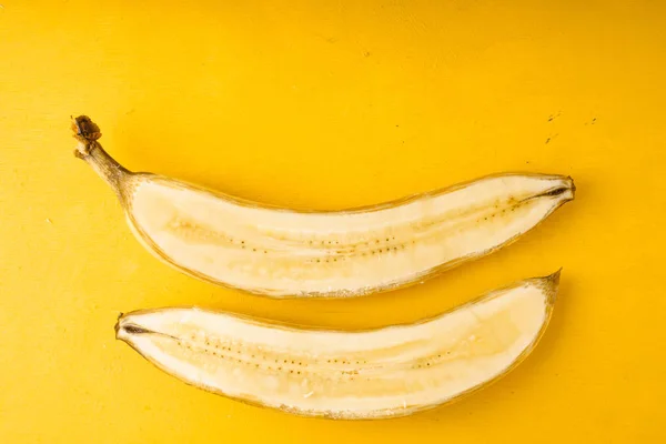 Plátano amarillo a la mitad sobre la mesa —  Fotos de Stock