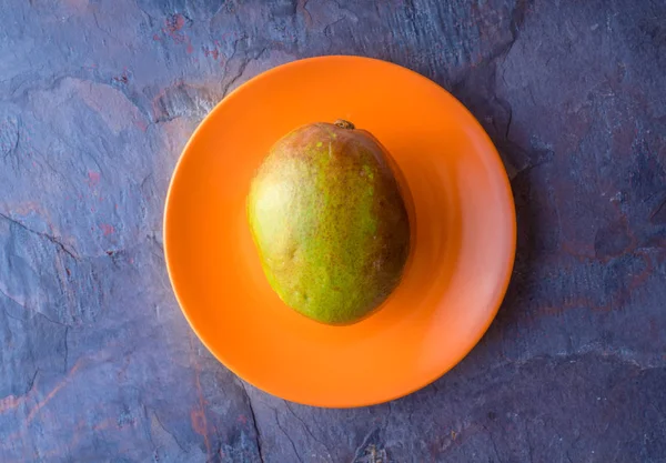 Mango is on the orange plate — Stock Photo, Image