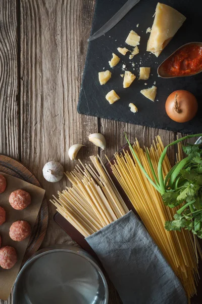 Ingrediënten voor spaghetti koken, gehaktballen met kaas en verse kruiden op de oude tabel — Stockfoto