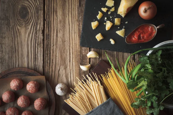 Ingrediënten voor spaghetti koken, gehaktballen met kaas en verse kruiden op tte tafel — Stockfoto