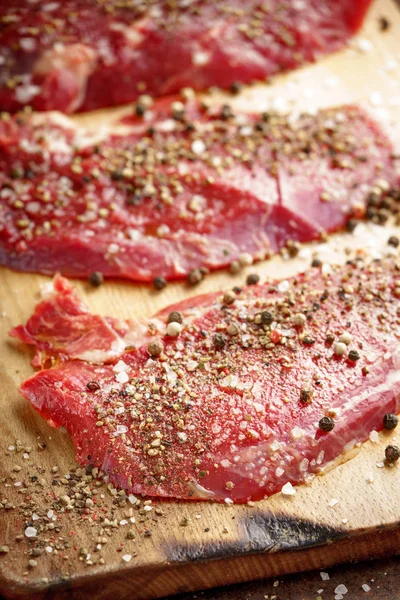 Raw beef steak and spicel on cutting board on the table — Stock Photo, Image