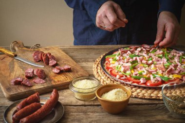 Mavi gömlekli adam mutfakta ev yapımı pizza yapar