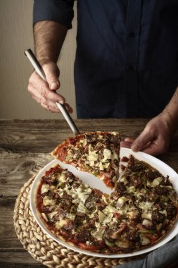 Pizza ve bir dilim pizza üzerinde beyaz bir tabak