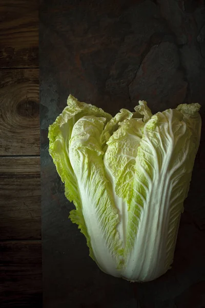 Chinese cabbage on a gray slate on old boards — Stok fotoğraf