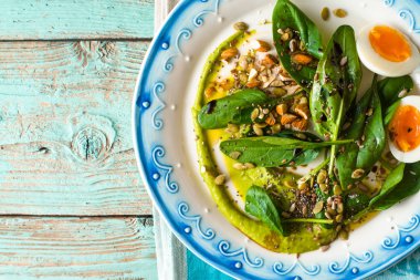 Avokado sosu ve açık mavi renkli üstten görünüm üzerinde yumurta ile ıspanak