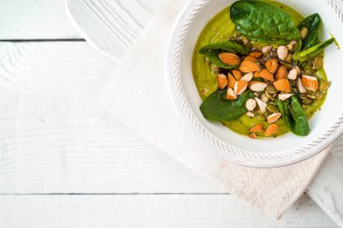 Avokado badem ve ıspanak üzerinde beyaz ahşap masa üstü görünümü ile krem