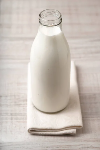 Kéfir en una botella de vidrio sobre la mesa —  Fotos de Stock