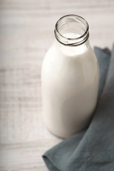 Kefir em uma garrafa de vidro na mesa de madeira — Fotografia de Stock