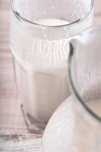 Glass of kefir and a jug on the wooden table — Stock Photo, Image