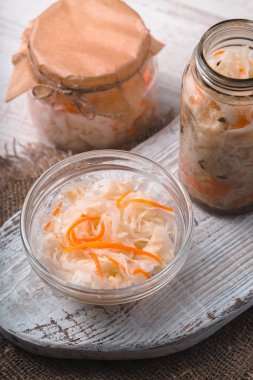 Bir kapta ve beyaz tahta üzerinde bankalarda lahana turşusu