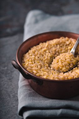 Tahıl bulgur bir bakır kase ve metal kaşık kısmi bulanıklık