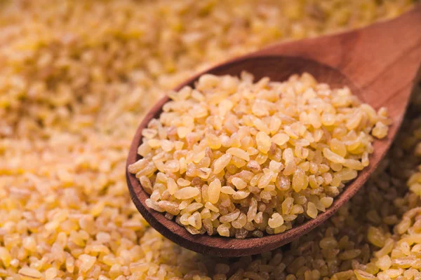 小麦籽粒和木勺的背景 — 图库照片
