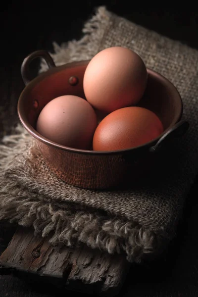 Cuenco Cooper con huevos de pollo en la mesa de madera vertical — Foto de Stock