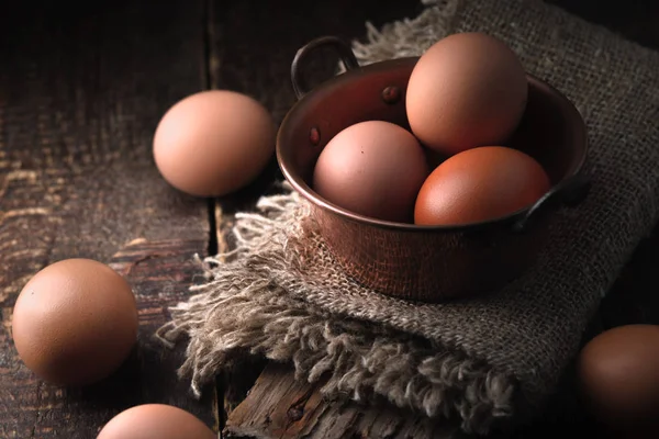 Huevos de pollo en la olla de gallina en la mesa de madera horizontal — Foto de Stock