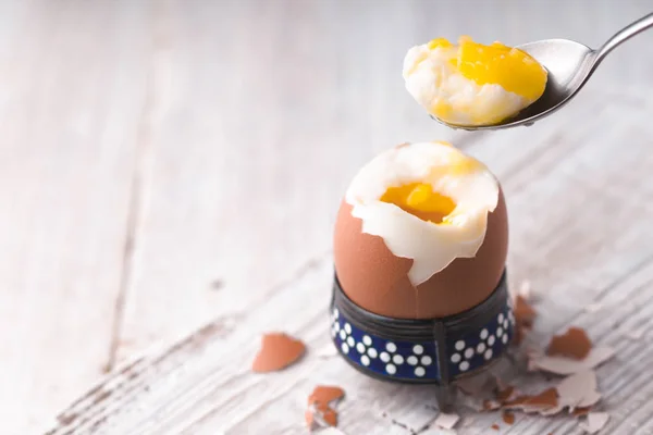 М'яко зварене яйце на білому дерев'яному столі горизонтально — стокове фото