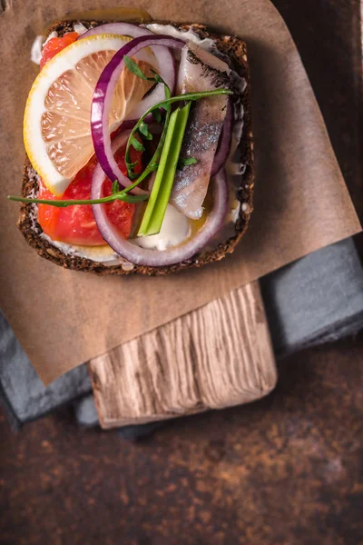 Danish sandwich with fish on the parchment closeup