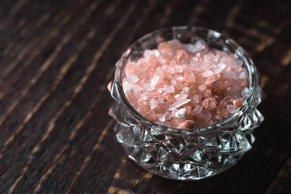 Lyserød salt i en skål på et træbord - Stock-foto