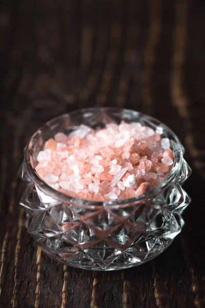 Pink salt i en glasskål på et træbord - Stock-foto