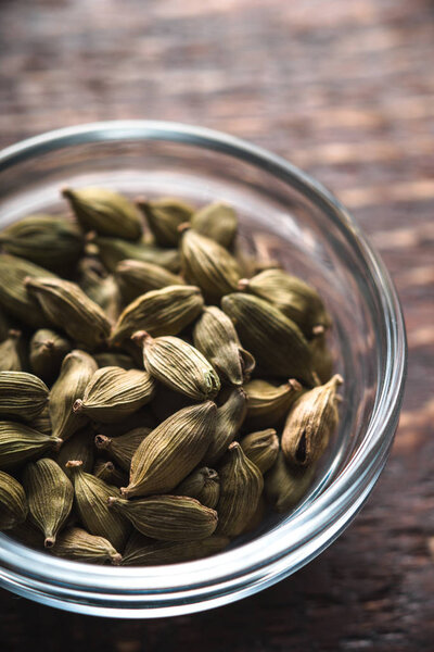 Семена кордамона в миске на столе частичное размытие
