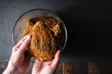 Kadın tavuk kalça bir kase içinde yağlar.