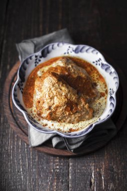 Peçeteye dalgalı kenarlı bir kapta sulu tereyağı tavuk