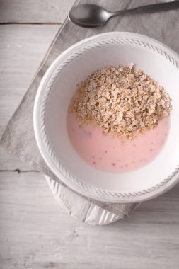 Beyaz ahşap masa üstü görüntüsü üzerinde meşe pul ile meyve yoğurt