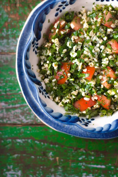 Salată de Tabouli din Orientul Mijlociu la un bol de sticlă deasupra șervețelului floral — Fotografie, imagine de stoc