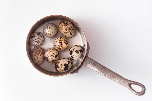 Ovos de codorniz numa panela velha. Em um fundo branco — Fotografia de Stock