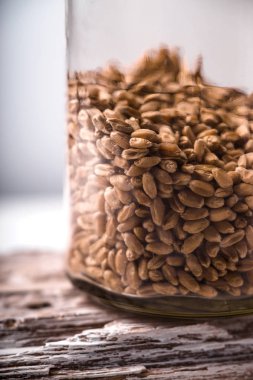 Buğday tohumu rustik bir tahta üzerinde cam kavanozda