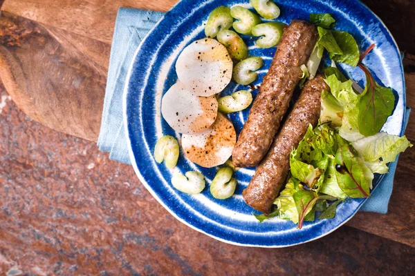 Chevanchichi avec laitue et daikon sur une plaque bleue — Photo