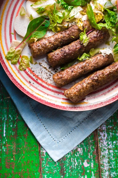 Chevanchichi with lettuce and daikon and celery on a brown plate — Stock Photo, Image