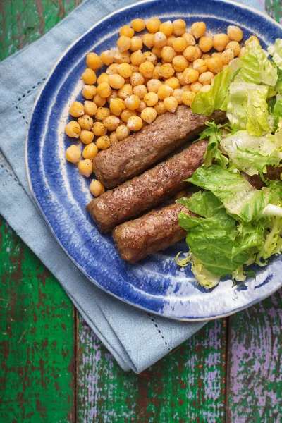 Chevanchichi with lettuce and chick-pea on a plate — Stock Photo, Image