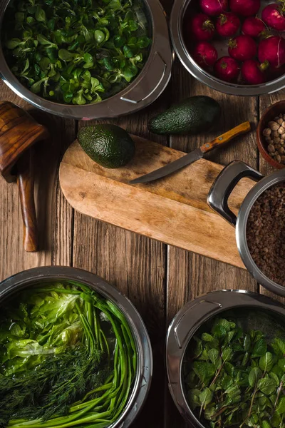 Avocado, green herbs in a bowl of water on the table — Stock Photo, Image