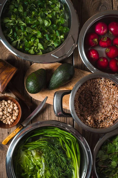 Buckwheat in a pot, green grass in the water and avocado on the table — Stock Photo, Image