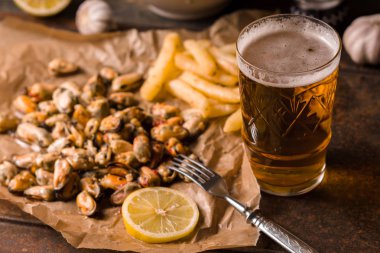 Midye, parşömen ve bir bardak bira patates kızartması