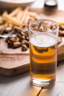 Bira, kızarmış patates, midye, limon parşömen yan görünüm