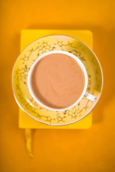 Csésze kávé tejjel, a sárga háttér felülnézet — Stock Fotó