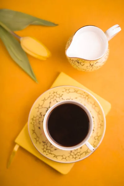 Чашка кави та молочного глечика на жовтому тлі вид зверху — стокове фото