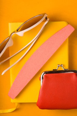 Gözlük, çanta sarı pop sanat arka plan üzerinde bir not defteri üzerinde