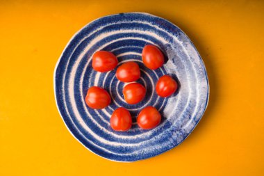 Kiraz domates plaka sarı ahşap masa üzerinde. Üstten Görünüm