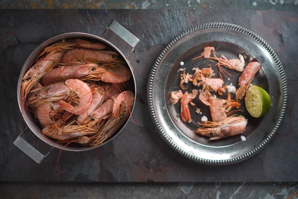 Pan with shrimps and a plate with shells from shrimps — Stock Photo, Image