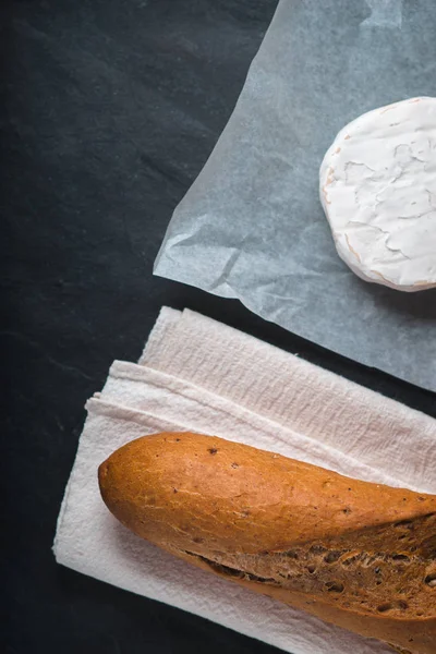 Сыр бри с хлебом на каменном фоне вертикальный — стоковое фото