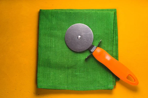 Knife for cutting pizza on the green napkin top view — Stock Photo, Image