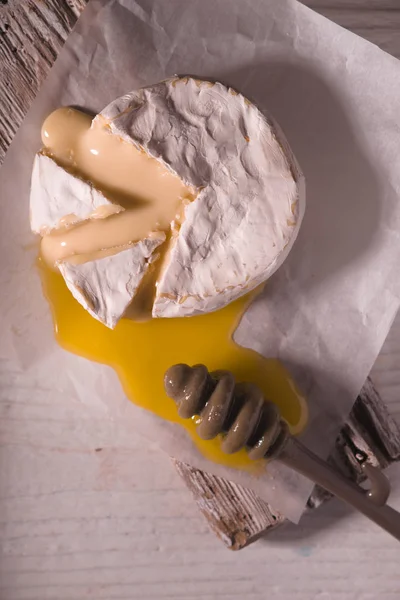 Brie cheese with honey on the white wooden  table top view — Stock Photo, Image